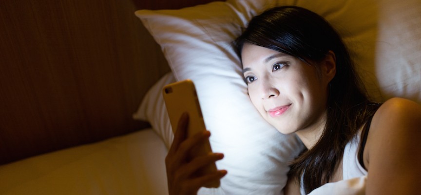 Kvinde planlægger at øge produktivitet ved at tjekke arbejdsmails søndag inden sengetid